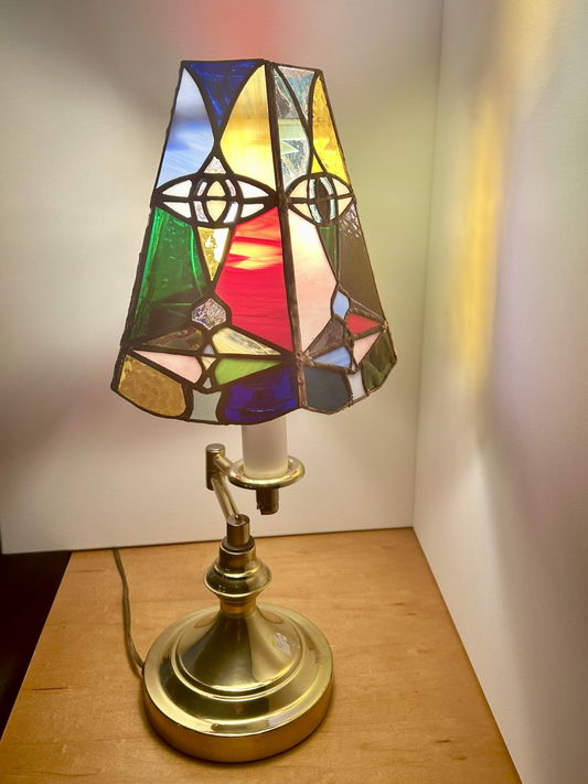 Stained glass lamp on a wooden surface with a plain background